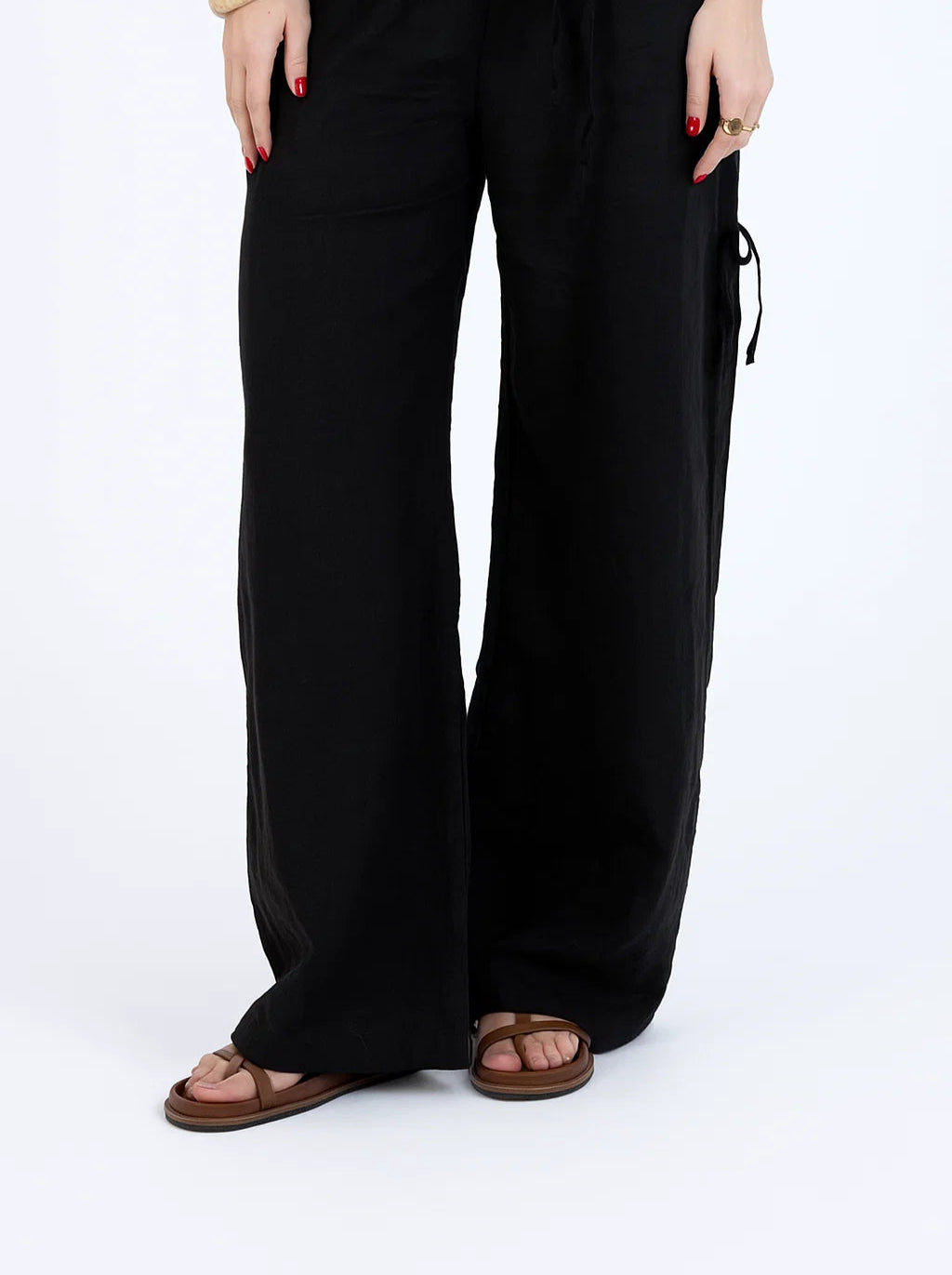 Person wearing black wide-leg pants on a white background